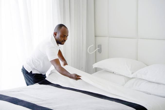 Hotel houseman transporting fresh linens in a hotel corridor